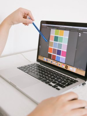 Close-up of hands using a laptop with a digital color palette, ideal for design work.